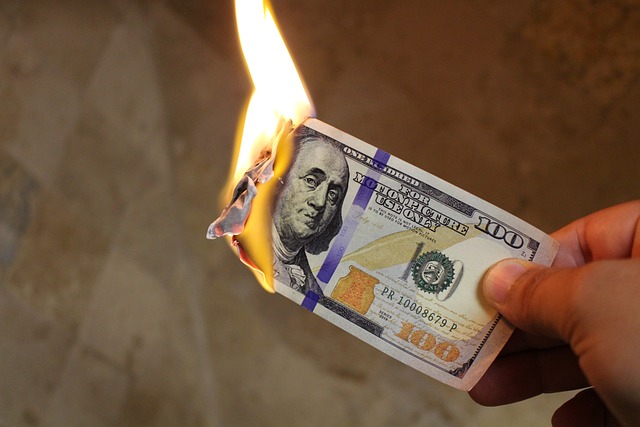 A burning dollar, symbolizing inflation and financial risks in the global economy.