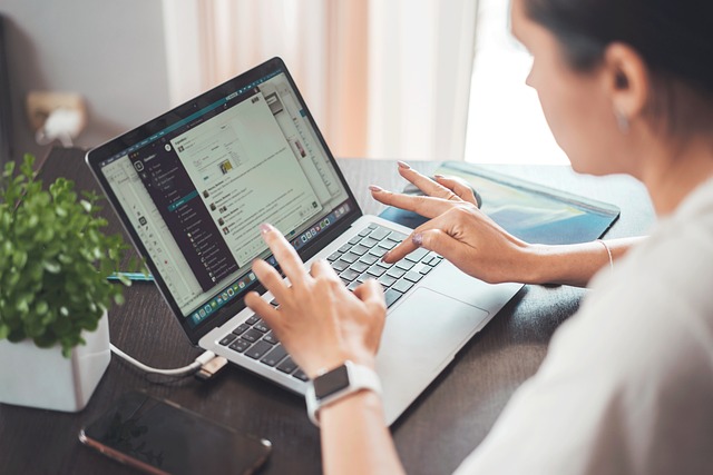 Woman working on her laptop, engaging in digital activities.